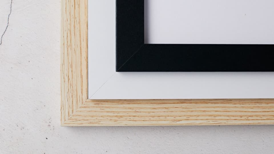 A wood, black, and white frame laid one over the over in a staggered pattern