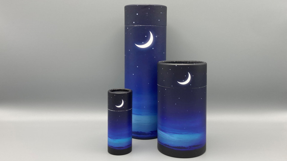 Cylindrical tubes with a decorated surface in three different sizes. The smallest and largest size are similarly proportioned while the middle size is relatively taller and narrower